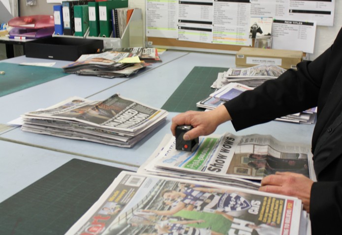 Carefully conserving a newsprint page Carefully conserving a newsprint page