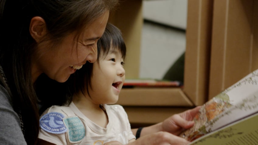 Woman and child reading a book together