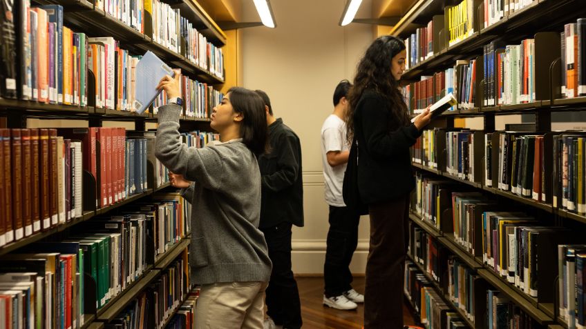 Students in the bookshelf stacks looking for books