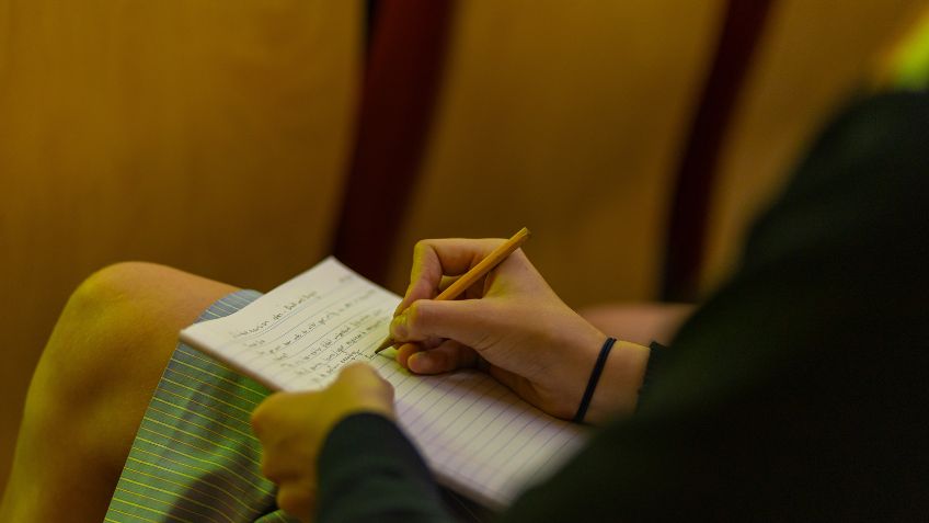 Student writing something down on a piece of paper