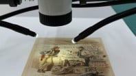 Image of a microscope positioned over an artwork