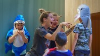 woman laughing with children in fancy dress