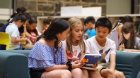 three teenagers reading a book