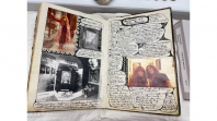 An open book with messy handwriting and images covering the pages