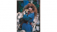 An image of Vali and Foxy from 1972, where Vali is wearing striking dark eyeliner, wild red hair and a deep blue dress.