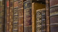 Rare leatherbound books on a shelf showing spines with gold lettering