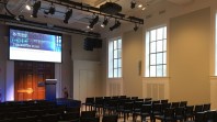 Rows of chairs face a screen