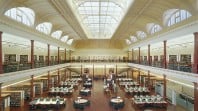 two-storey gallery with ornate glass roof, library stacks, desks and chairs