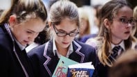 Colour photo of schoolgirls reading Young Adult books