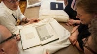 Picture of a group of people viewing a rare book