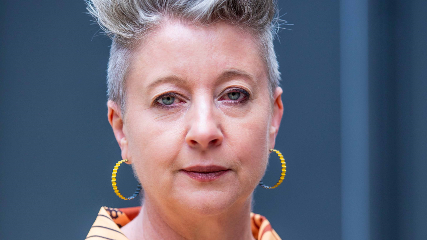 Photo of a woman with short, grey hair looking at camera.