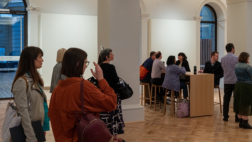 people standing and seated in meeting space
