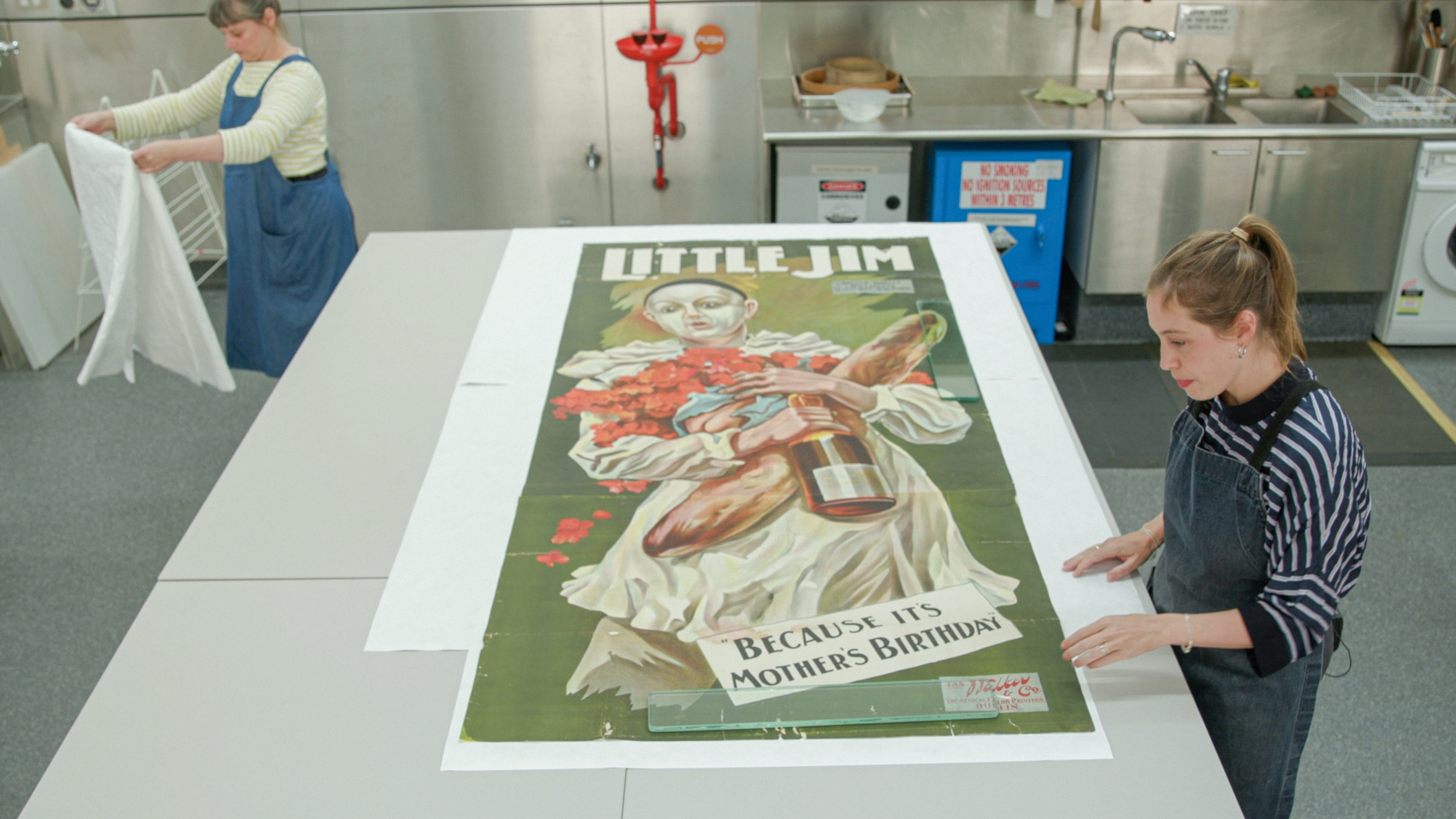 Large poster on a table and two people around it