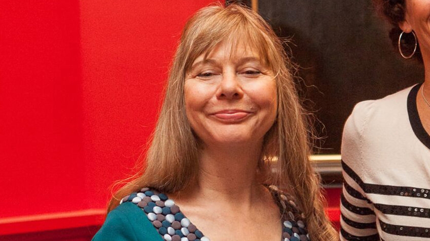 woman with blonde hair and blue dress against a red background