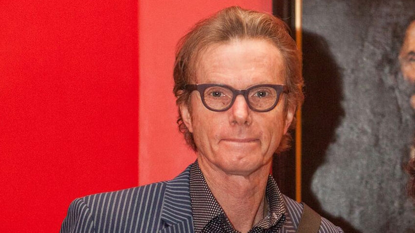 man with spectacles against red background