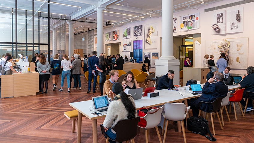 Library Russell Street foyer with cafe customers, whie pillars and people at desks