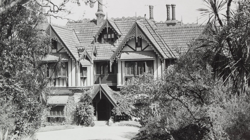 Black and white exterior photo by John T Collins of Tay Creggan in Hawthorn, a double-storey residence with imitation half-timbering, decorative timber barge-boards, steep gables and a tiled roof