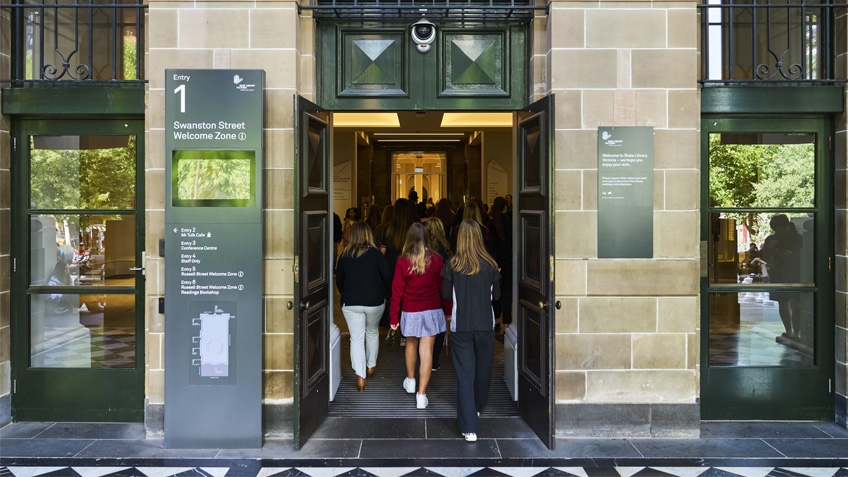 Group of school kids with teacher entering through main Swanston Street entrance of Library