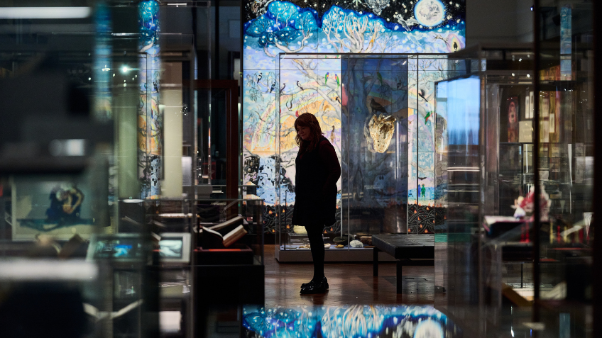 A person looking at artwork inside the Creative Acts exhibition
