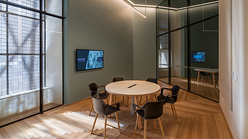 A round table encircled by six empty chairs