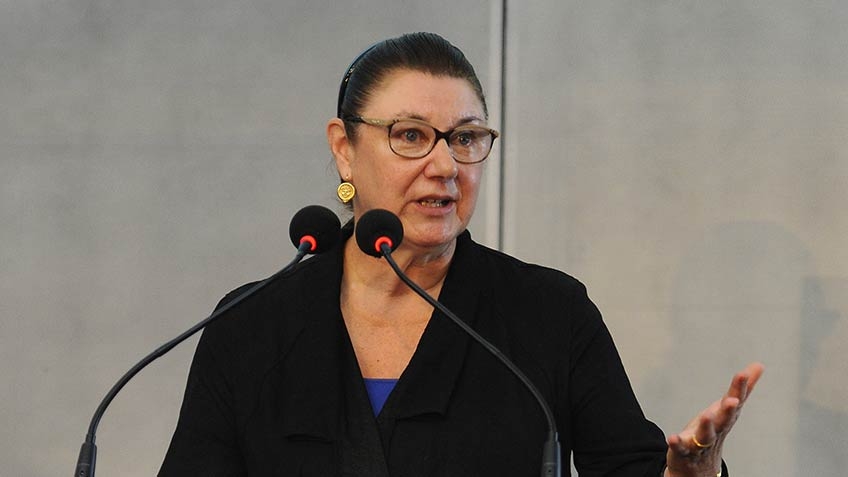 Susan Scollay speaking behind a lectern