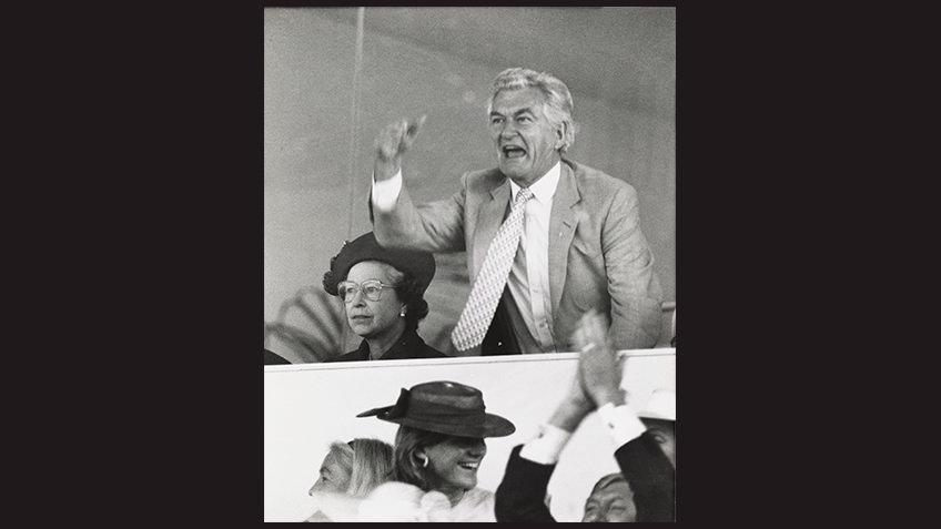 black and white photo of victorious Bob Hawke and frowning Queen Elizabeth