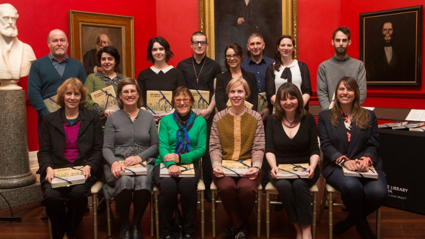 2015 Creative Fellows group photographed against red walls and paintings of Red Rotunda