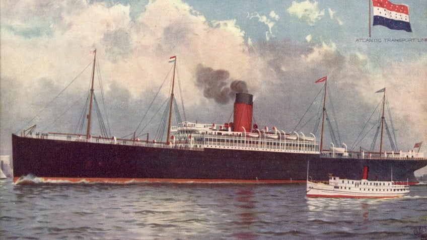 A large ship floating on water with clouds behind it
