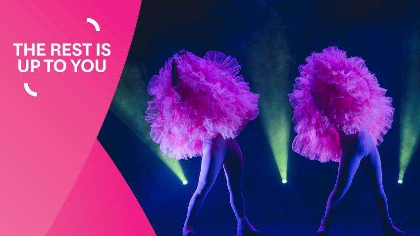 A Fringe performance at the Library with two dancers wearing large pink tutus over the top half of their bodies with green back lighting