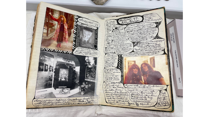 An open book with messy handwriting and images covering the pages