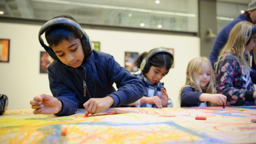 Polyglot Theatre productions, with child drawing what their listening to through headphones