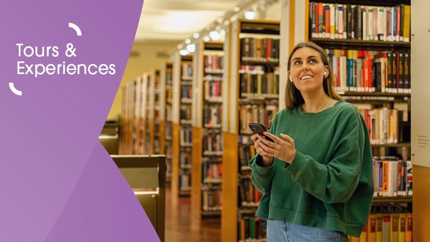 Image of a brunette woman in a green top and jeans holding a mobile phone in the Library. On the left is a purple graphic overlay with white text that says 'tours and experiences'.