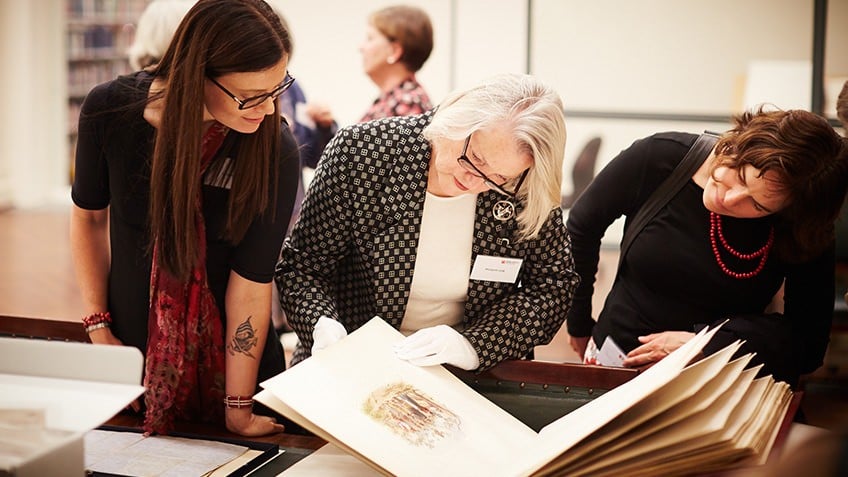 Photo of people looking at a rare book