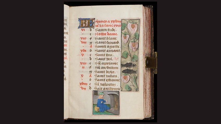 medieval manuscript page against black background with floral details