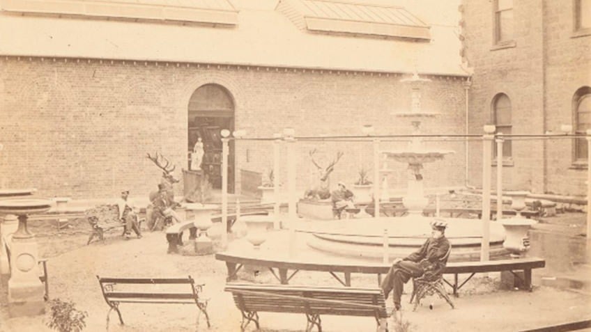 faded photo of men seated in exhibition courtyard