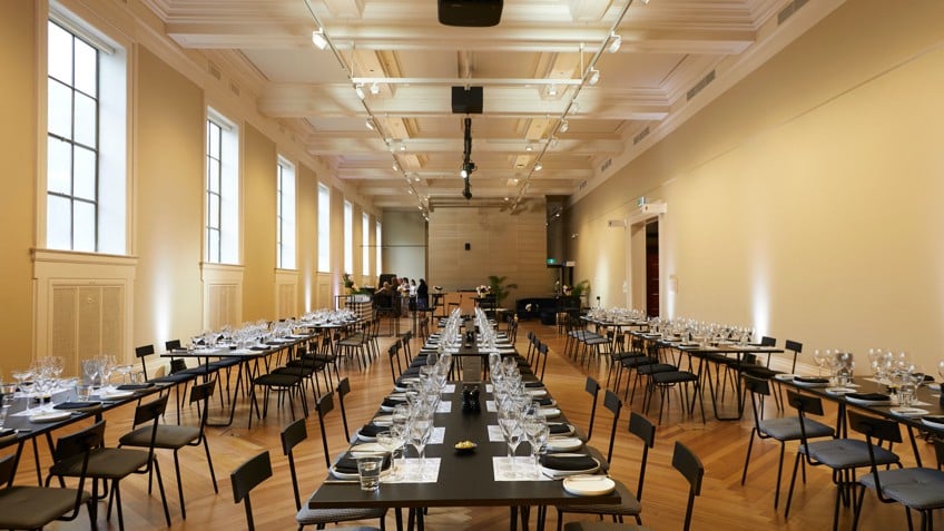 Rows of tables are laid with crystal glasses and plates