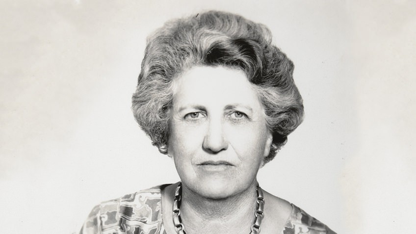 B&W headshot photo of middle-aged woman looking at camera without smiling