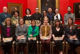2015 Creative Fellows group photographed against red walls and paintings of Red Rotunda