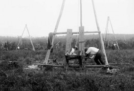 1920-1925 glass negative image. Early bore holes, testing coal. Shows men operation mining windlasses