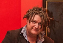 Robert Reid man with dreadlocks against a red background and oil painting