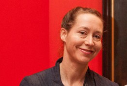 Yasmin Kelsall smiling woman against red background
