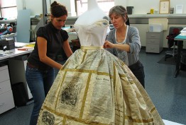 Photo of two women putting the Press Dress on a mannequin