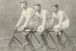 Sepia image of three Victorian-era men riding a tandem bicycle
