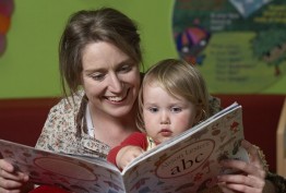Photograph of mother reading a story to child