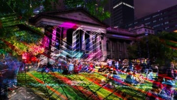 Photo of the front of the library lit up by coloured lights