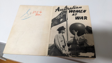 Interior title page of Australian Women at War edited by Mollie Bayne, featuring title and black and white photo of two women in military uniform with the Australian flag in the background.