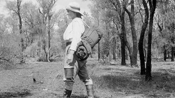 Black and white photo of a women walking in the Australian bushland