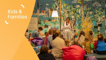 Group of children watching a woman tell a story