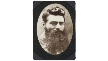 Black and white headshot photograph of Ned Kelly, a man with dark hair and long beard.