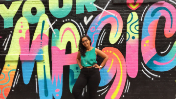 Woman standing in front of a graffiti wall